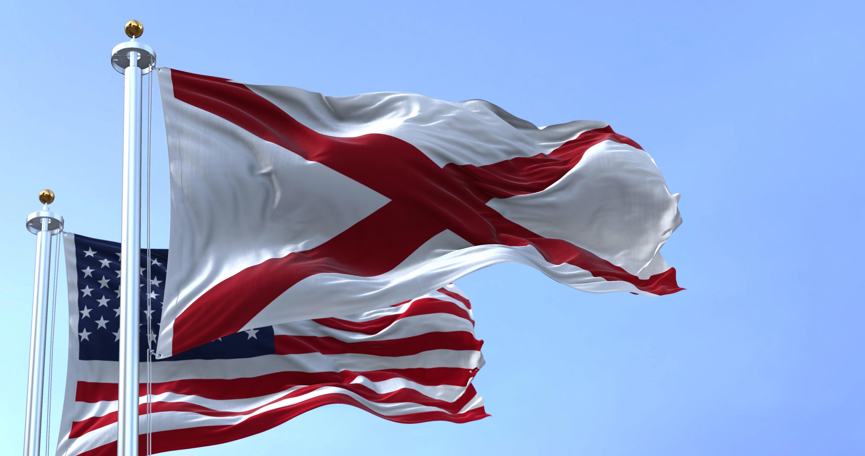 Alabama state flag and the American flag waving in the wind
